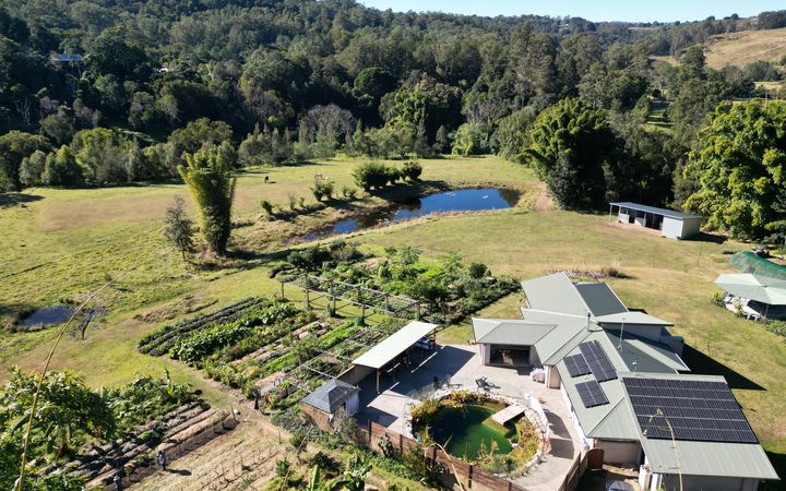 Aerial view of an off-grid homestead — solar roof, market garden, natural pool and dam