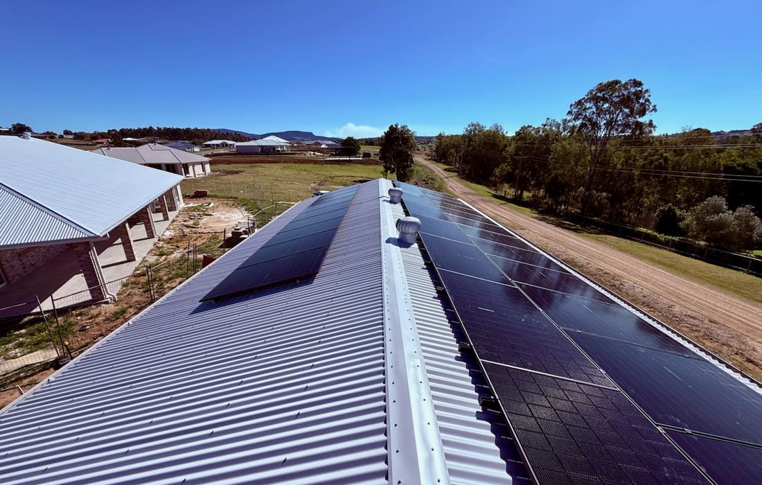 Black-glass solar array on a corrugated roof on a rural block